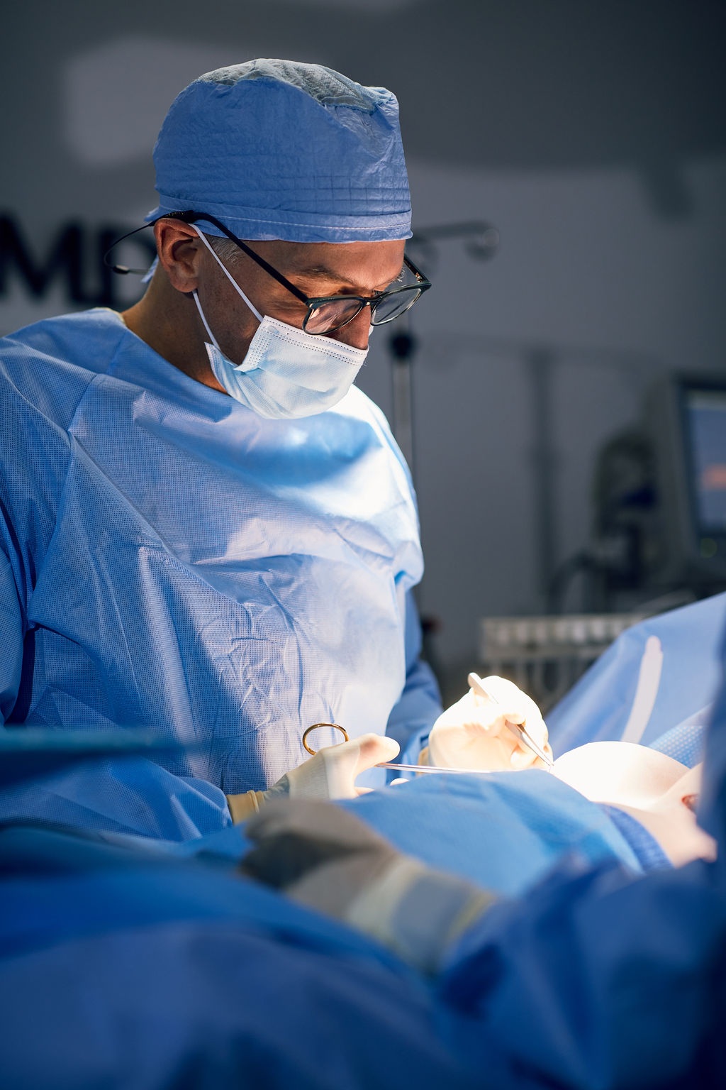 Dr. Peter Capizzi board certified plastic surgeon in operating room completing a breast augmentation