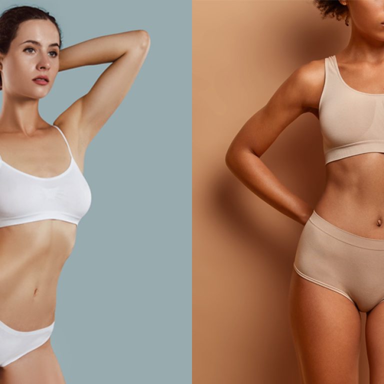 Two women displaying the results of their breast augmentation surgery.