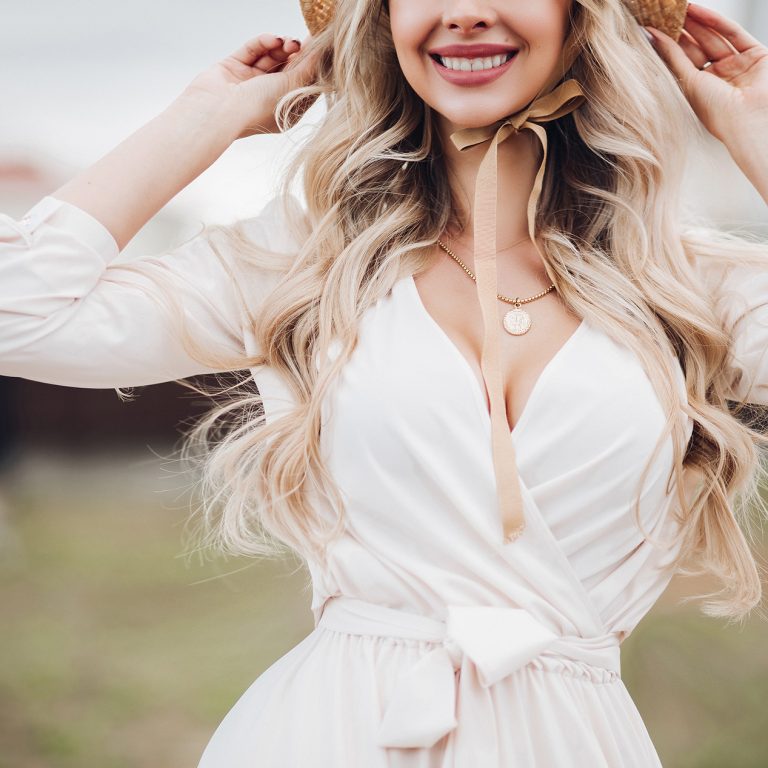 Gorgeous Blonde Woman With Long Wavy Hair Wearing Hat With Bows Showing Some Cleavage