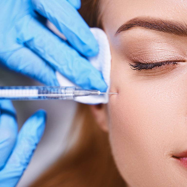 Young female is preventing wrinkles on her face by getting a liquid facelift.